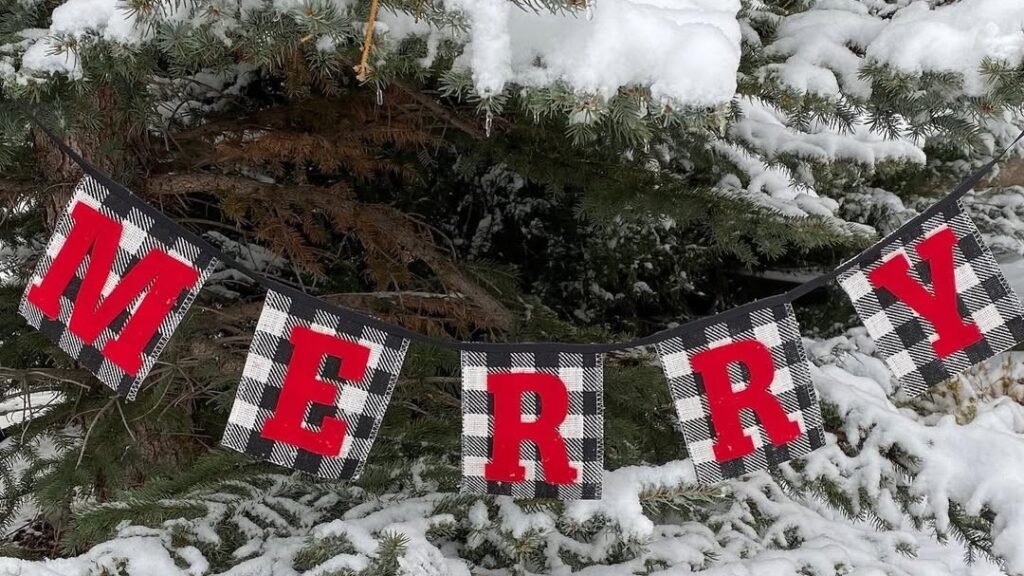 Black and white buffalo check MERRY banner hanging on a snow covered pine tree