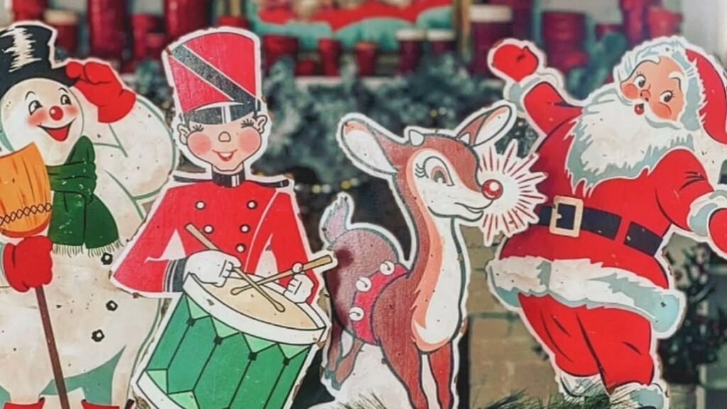 Four vintage Christmas decor cutouts standing side by side: a smiling snowman, a toy soldier playing a green drum, a reindeer with a glowing red nose, and a waving Santa Claus.